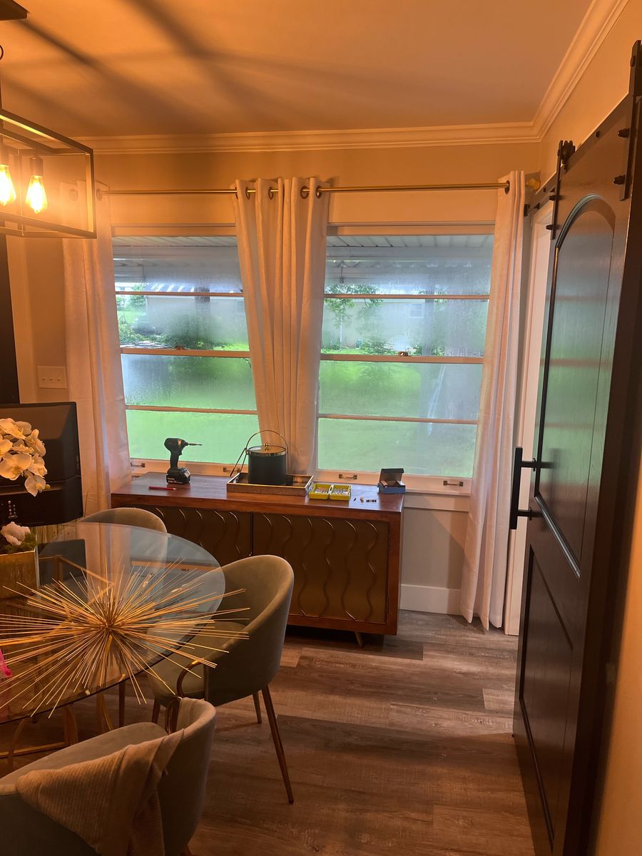 Dining room with a sliding barn door and curtains hung on a new curtain rod